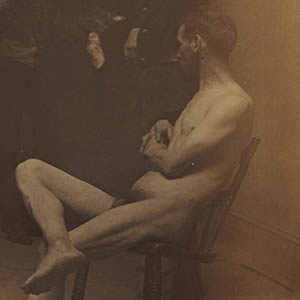 Three Male Nudes: Two Seated, One Standing with Spectators in Background, from The Grafly Album